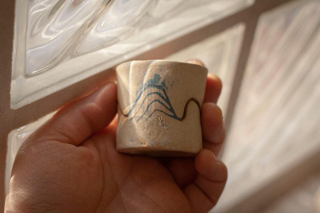 Person hält weißen Keramikbecher